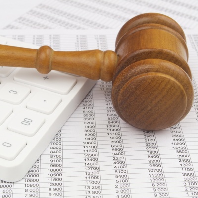A judge's gavel lies on top of papers with numbers and a calculator. We also provide advice on all aspects of criminal tax law.